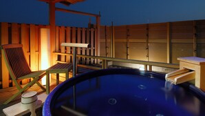 A hot tub area with wooden furniture and a view of the moon. - Dogo Prince Hotel (Matsuyama)