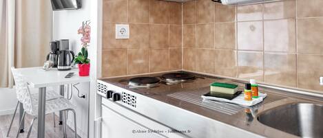 A modern kitchen with a gas stove, microwave, and a small sink.