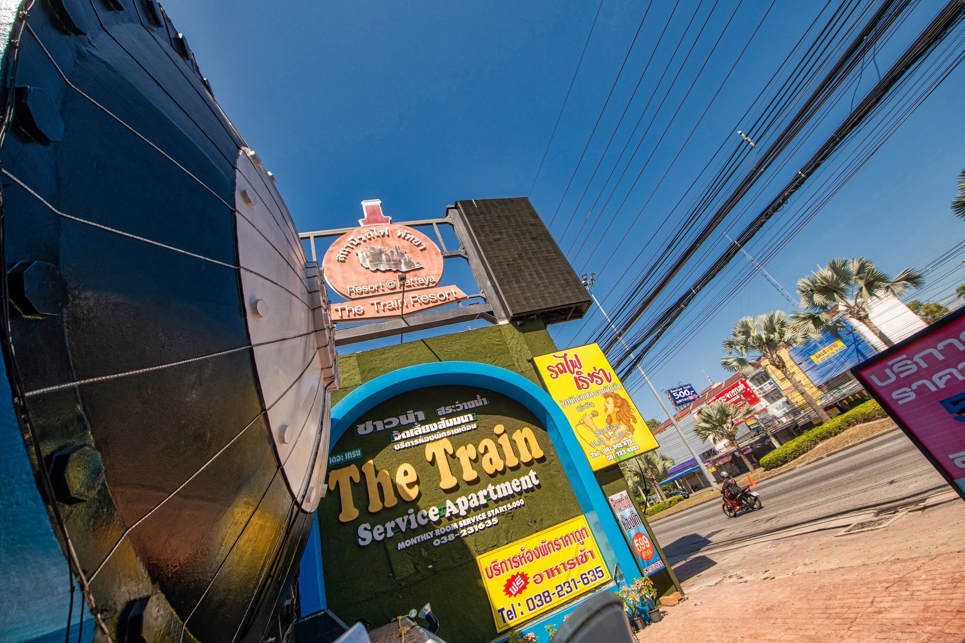 A train-themed service apartment with a large sign advertising it as a resort.