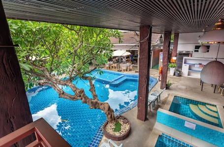 Una piscina al aire libre, sombrillas, sillones reclinables de piscina