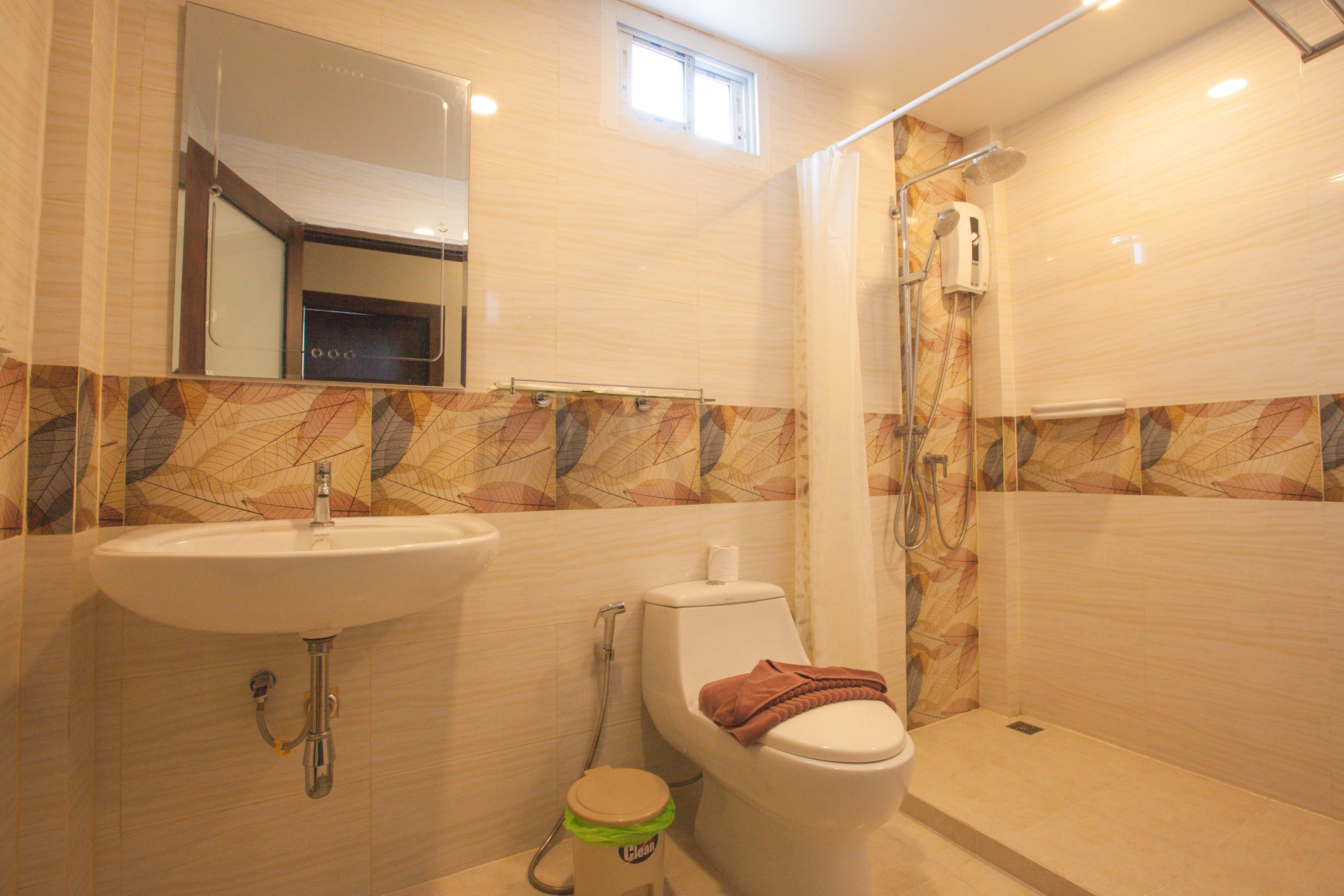 Een badkamer met wastafel, toilet en douche.