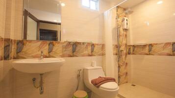 Een badkamer met wastafel, toilet en douche.