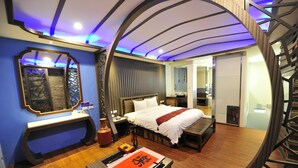 A modern bedroom with a curved ceiling, a bed, a bedside table, and a mirror. - Yudali HR Motel (Donggang)