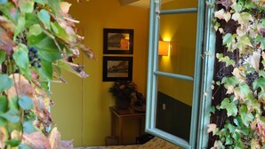 Une pièce comprenant un lit, une petite table avec un vase et deux tableaux encadrés accrochés au mur.