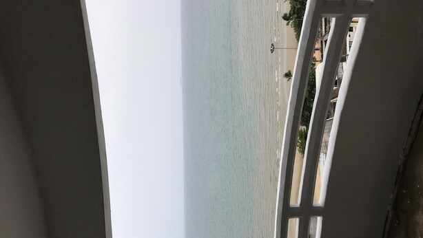 A view of the sea from a balcony with white railings and a concrete wall. - Bua Khao Paradise (Pattaya)