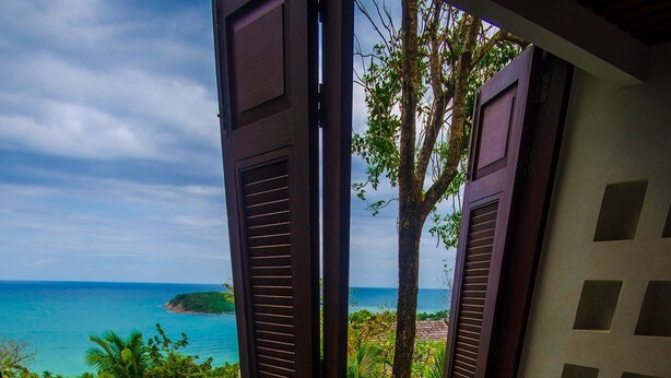 A bathroom with a bathtub and a view of a tropical beach and ocean. - Bhundhari Residence Koh Samui (Koh Samui)