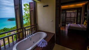 A balcony with a large bathtub, a bed, and a view of the ocean. - Bhundhari Residence Koh Samui (Koh Samui)