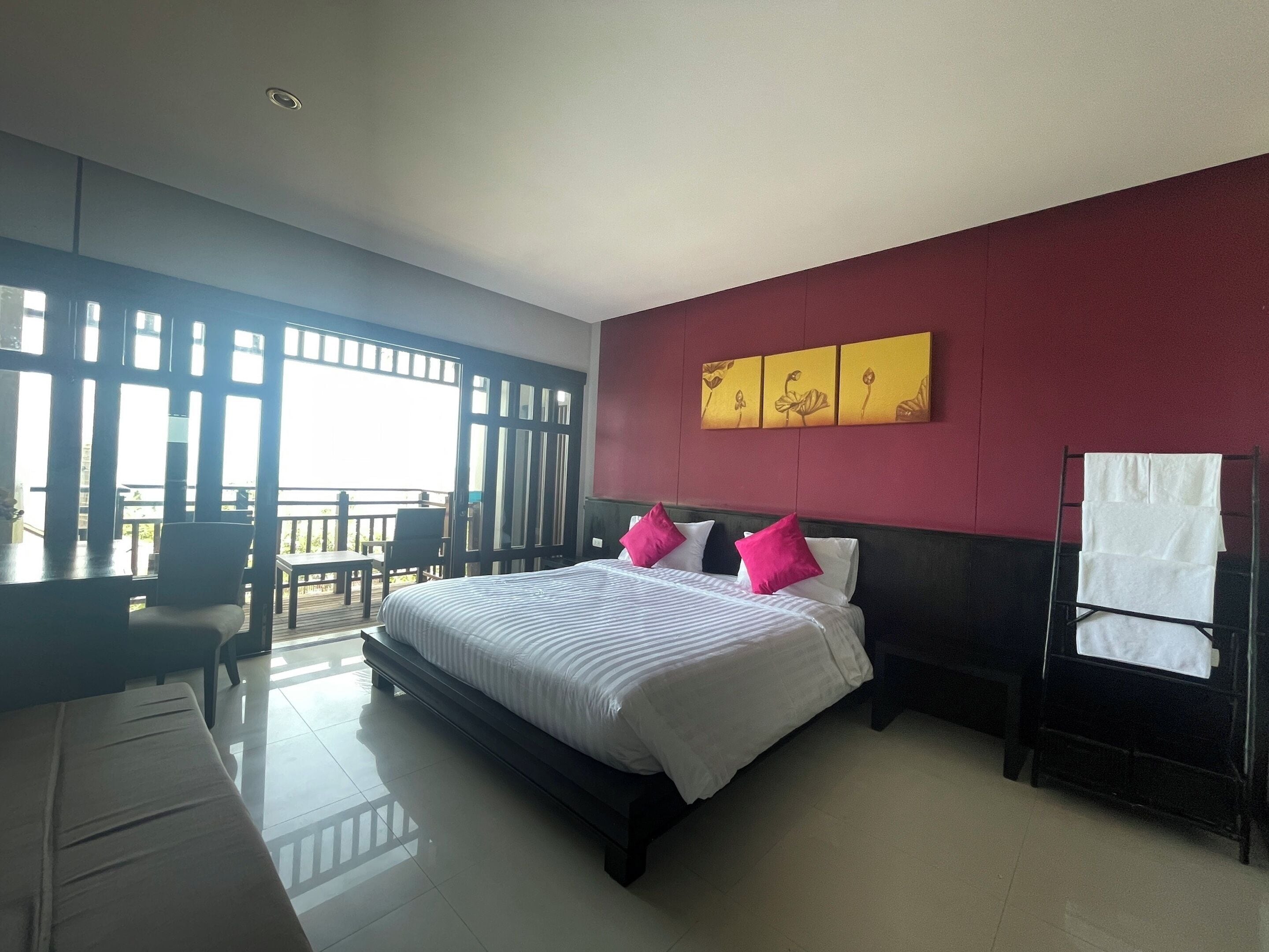 Une chambre d’hôtel avec un grand lit, un bureau et un balcon.