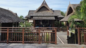 A traditional wooden building with a sloped roof and a central entrance. - Bhundhari Residence Koh Samui (Koh Samui)