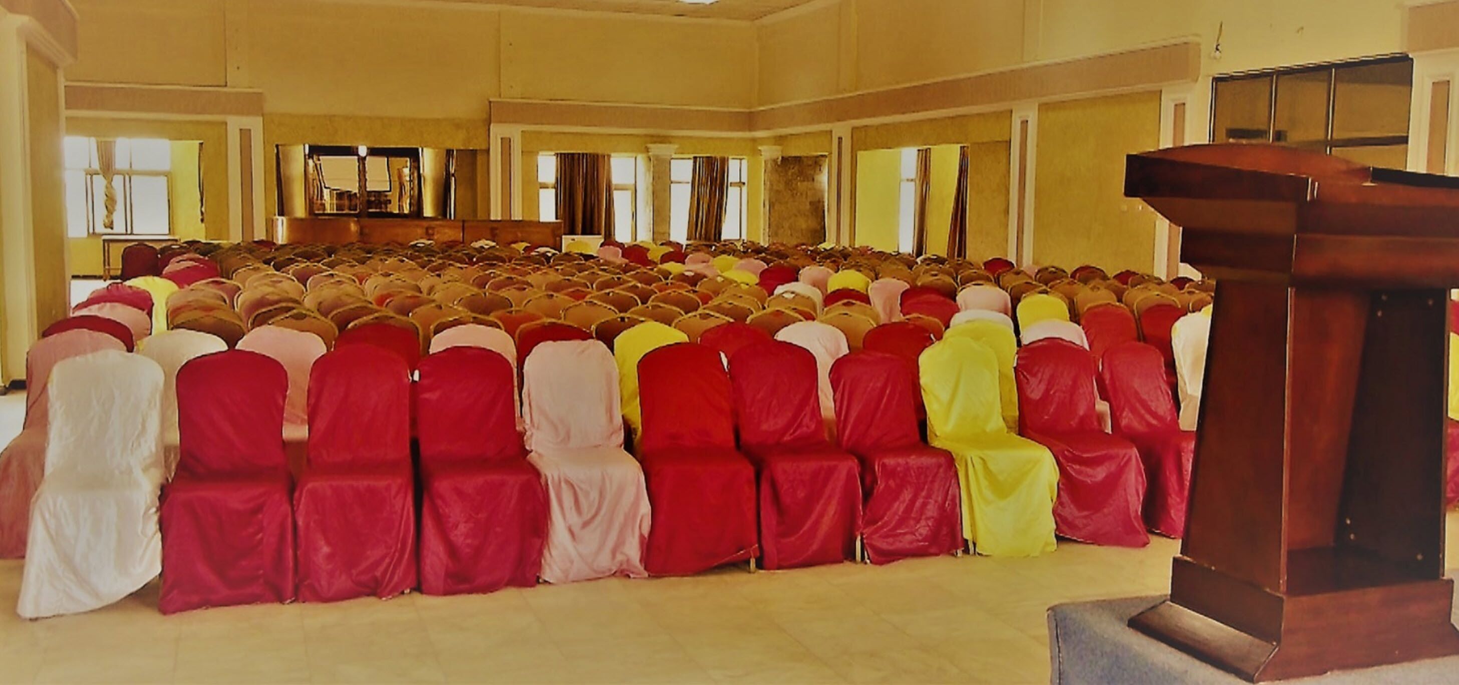 A large hall with rows of chairs covered in red and white.