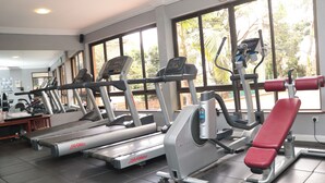 A gym with treadmills, ellipticals, and a bench.