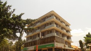 Et hotel med flere etager og altaner, et grønt skilt for Mosi-afdelingen af Bank of Africa, og et skilt for Panama Hotel Ltd.