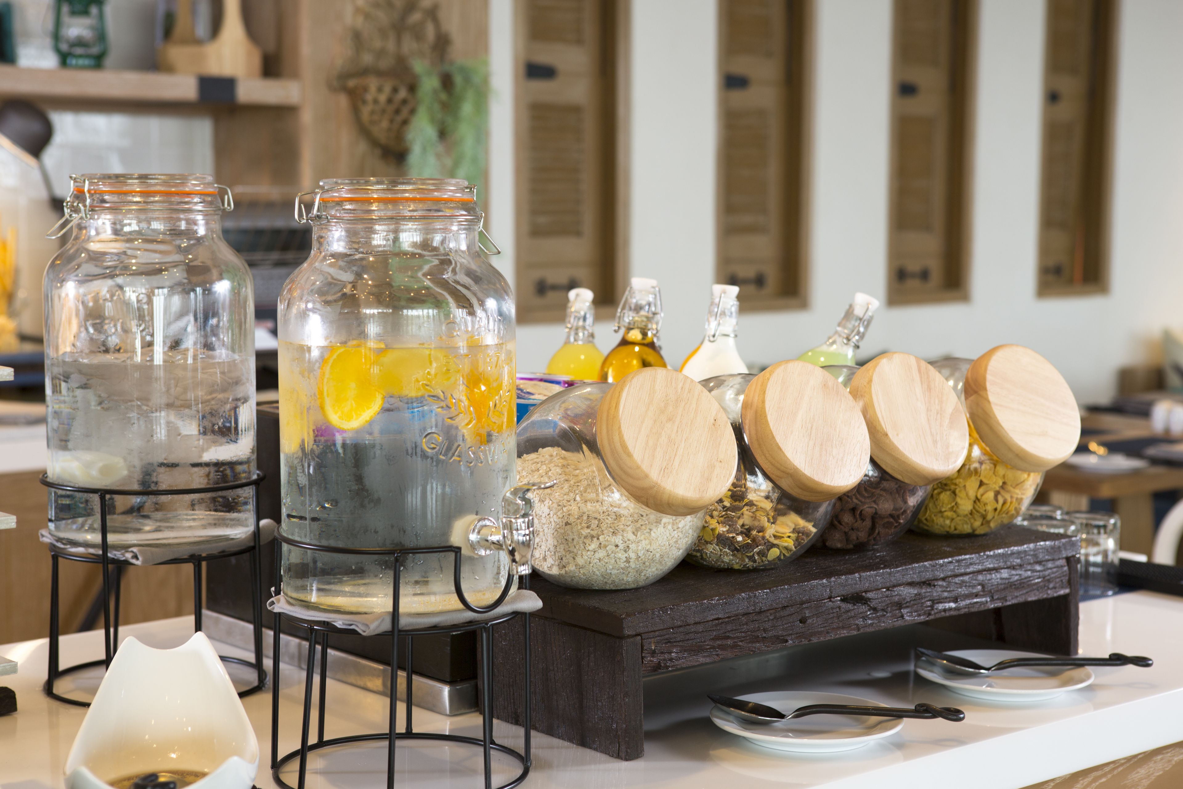 Un comptoir de cuisine sur lequel on trouve des bocaux en verre contenant divers aliments, ainsi qu’une planche en bois avec des pots d’épices.