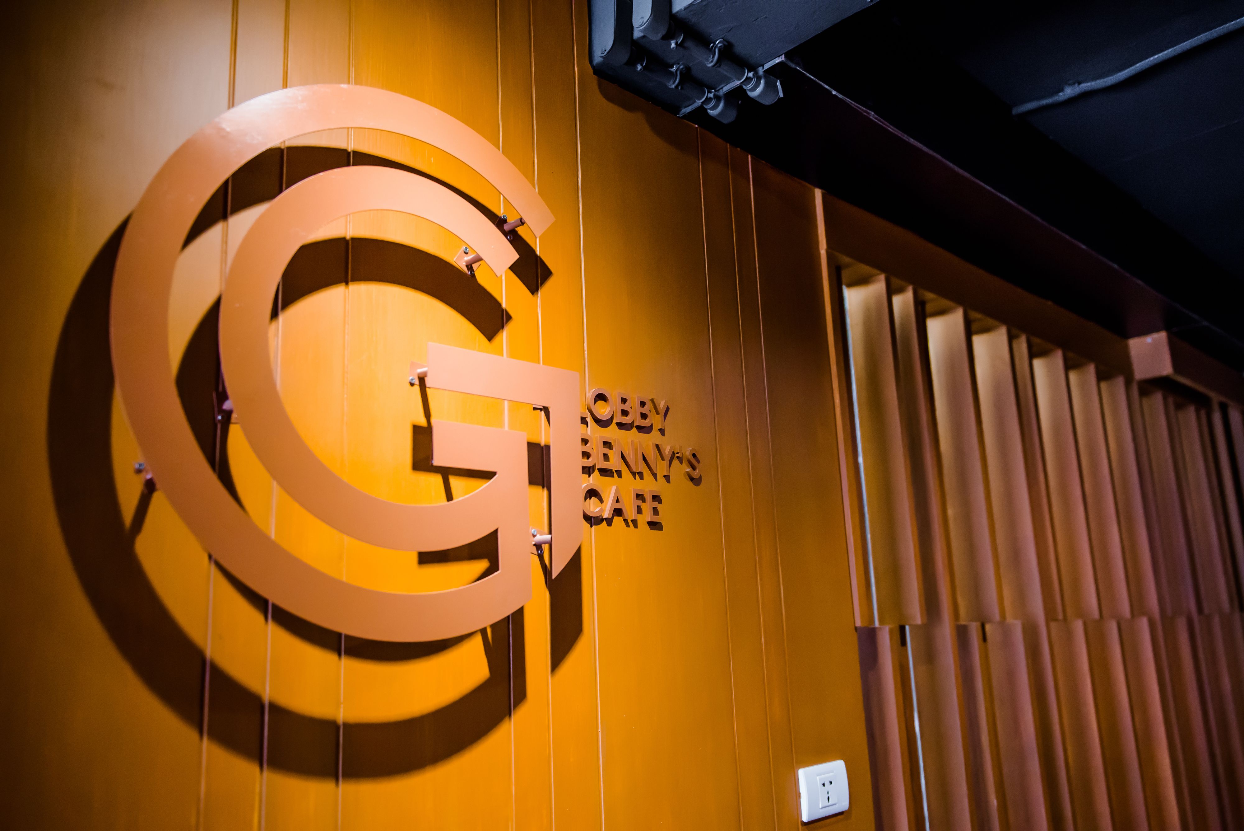 A wall with a large circular sign and the text "OBBY BENNY'S CAFE".