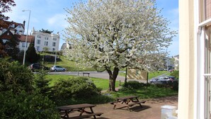 A park with picnic tables and a blooming tree. - Russell Hotel (Royal Tunbridge Wells)