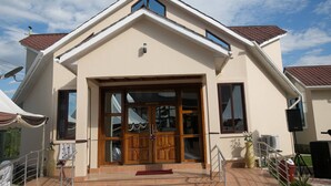 A building with a prominent entrance, large windows, and a tiled roof. - Samanene Beach Hotel (Mwanza)