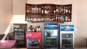A bar area with shelves of liquor bottles and three beverage dispensers labeled Coca-Cola, Pepsi, and Barani. - Samanene Beach Hotel (Mwanza)