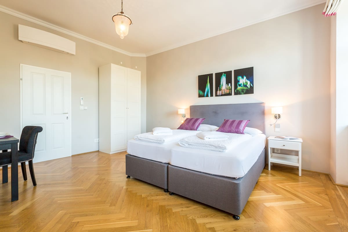 A bedroom with a double bed, bedside tables, a chair, and a desk.