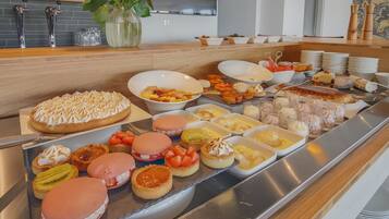 A buffet with various desserts and fruits.