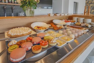A buffet with various desserts and fruits.