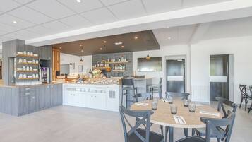 A modern kitchen with a central island, bar area, and dining space.