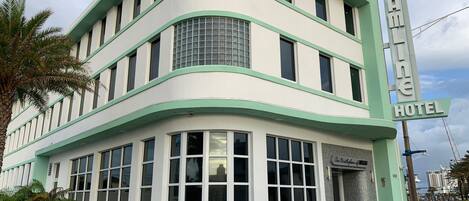 A hotel with a distinctive Art Deco facade, large windows, and a prominent sign reading "Streamline Hotel."
