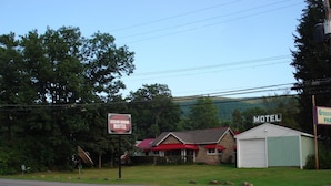 A Cedar Grove Motel with a red awning, a green garage, and a signboard. - Cedar Grove Motel (Altoona)