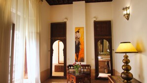 Una habitación con una mesa de madera, una lámpara y un cuadro en la pared.