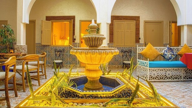 A courtyard with a central fountain, seating area, and arched doorways. - Riad Hotel El Kennaria (Marrakech)