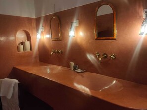 A bathroom with two sinks, a mirror, and a towel rack.