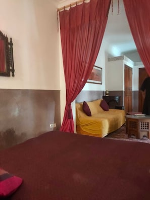A room with a bed, a sofa, and a small table.