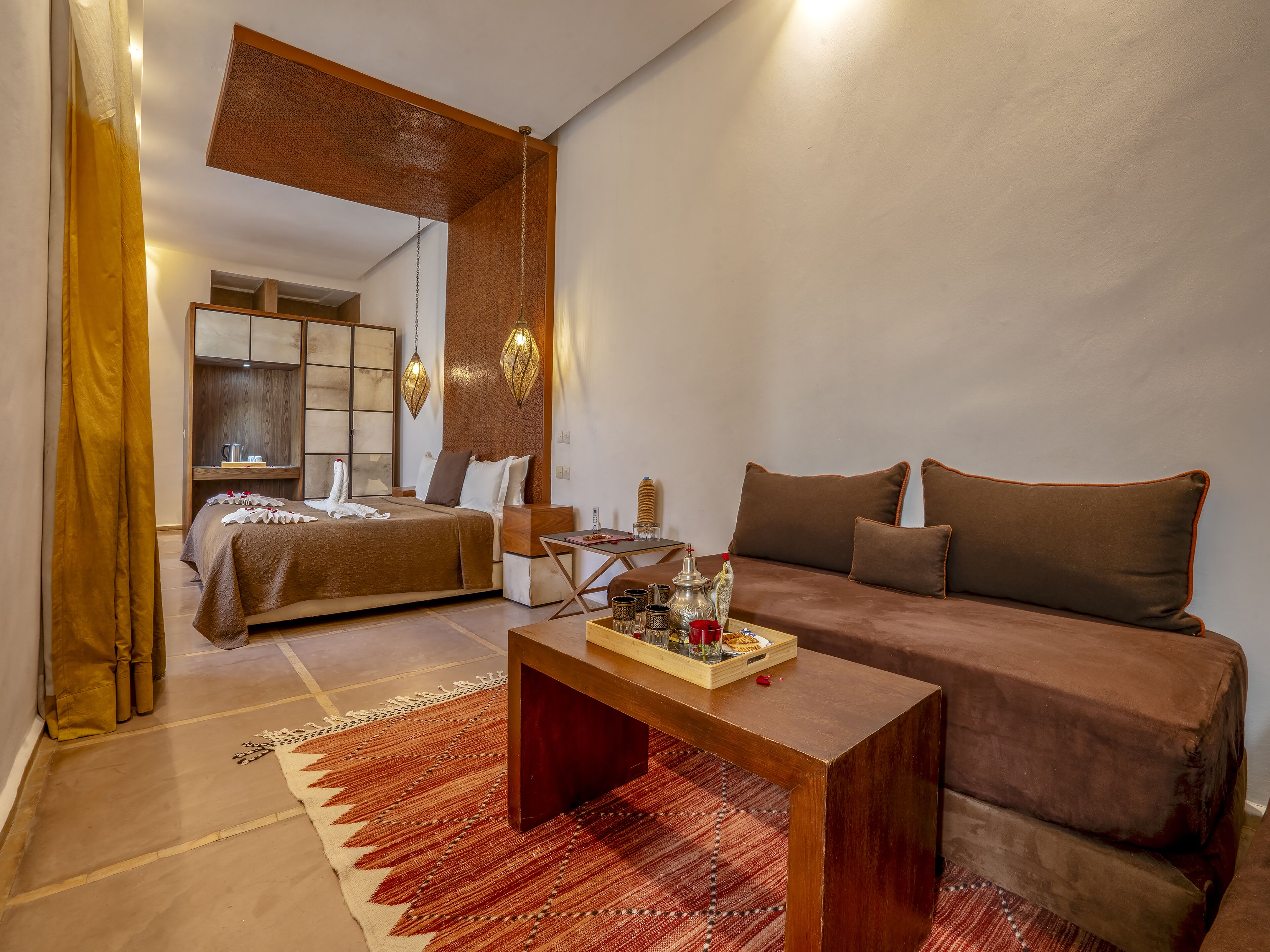 Ein Hotelzimmer mit einem Bett, einem Sofa, einem Couchtisch und einem Esstisch.