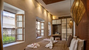 Une chambre d’hôtel avec un grand lit, deux fenêtres, un bureau et un mur décoratif.