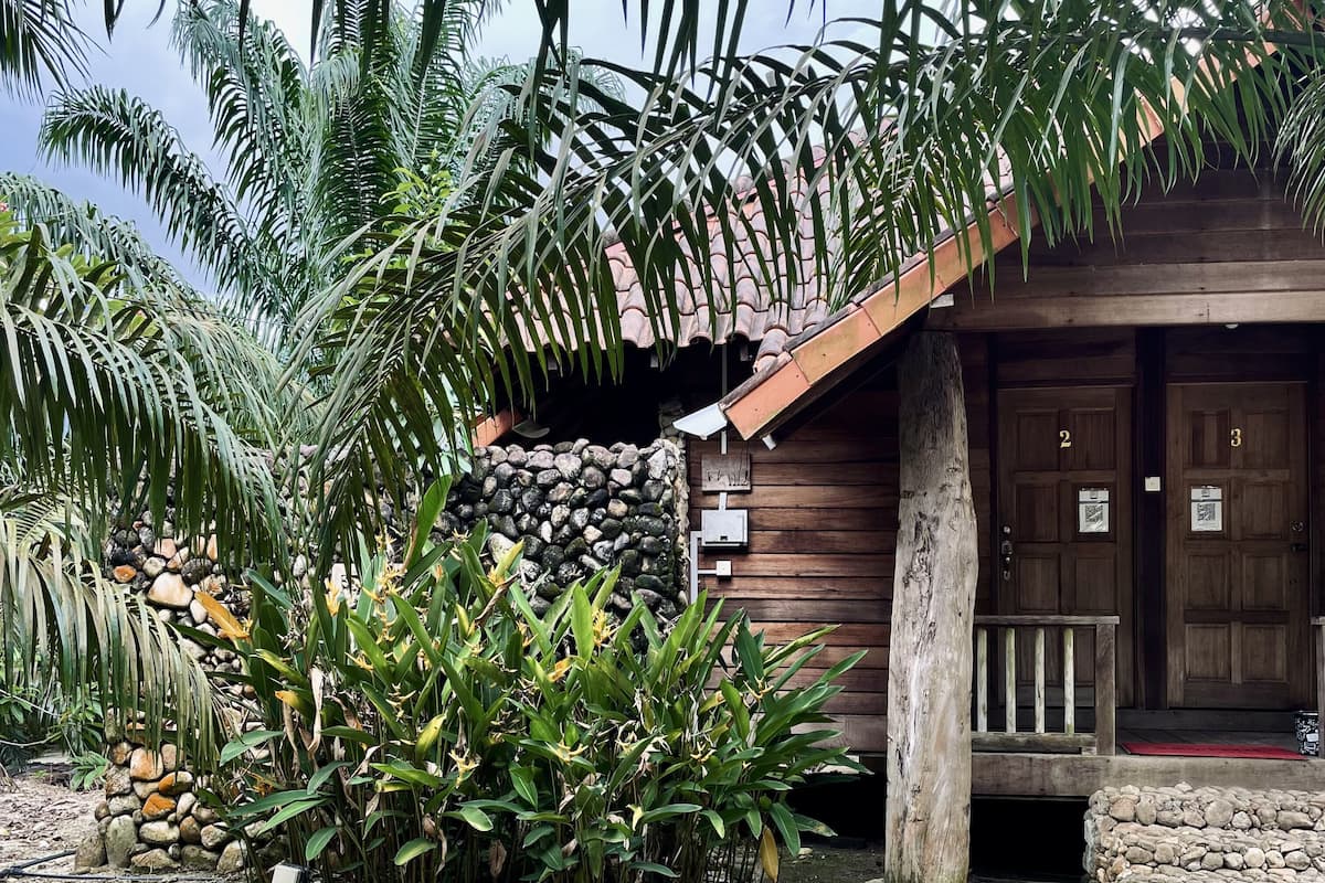 A rustic wooden building with a stone wall and a wooden porch.