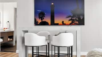 Relax in this stylish living room with a large flat-screen TV, L-shaped dining table, and plush sofa.