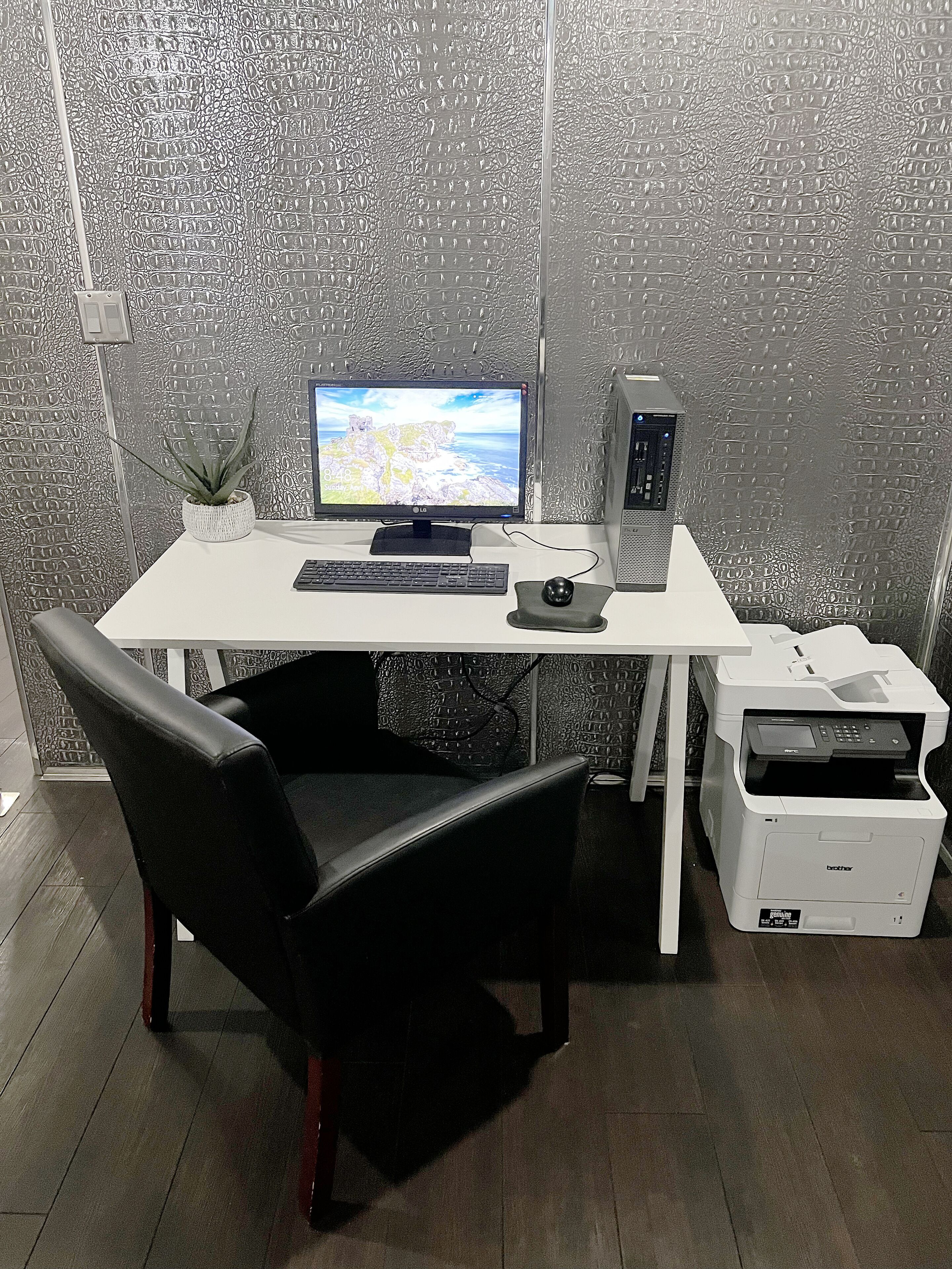 Ein moderner Schreibtisch mit Computer, Tastatur, Maus und Drucker.