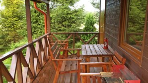 Une terrasse en bois avec des tables de pique-nique et un barbecue.