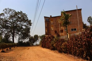 Un edificio con fachada de ladrillo, varias ventanas y una cerca alrededor.