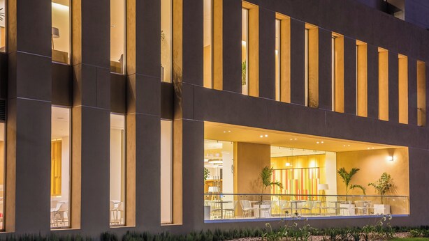 A modern building with large windows and a well-lit interior. - Fiesta Inn Silao Puerto Interior (Silao)