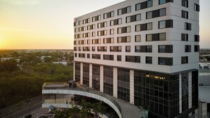 A multi-story hotel with a modern design, featuring a large glass facade and a curved entrance.