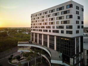 A multi-story hotel with a modern design, featuring a large glass facade and a curved entrance.