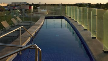 Alberca al aire libre y camastros