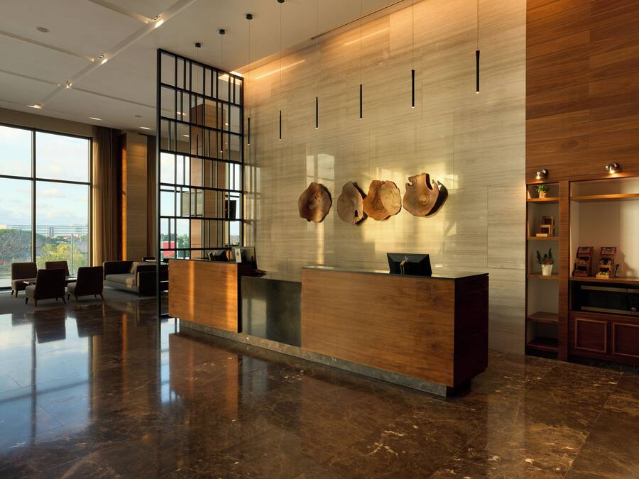 A modern reception area with a wooden reception desk, large windows, and a city view.