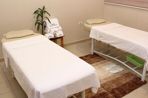 A treatment room with two beds, a green basket, and a plant. - Howard Johnson by Wyndham Ciudad del Este (Ciudad Del Este)
