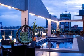 A rooftop pool area with lounge chairs, a swimming pool, and city views. - Howard Johnson by Wyndham Ciudad del Este (Ciudad Del Este)