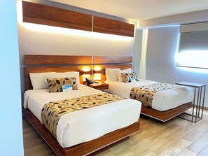 A hotel room with two beds, wooden headboards, bedside tables with lamps, and a large window. - Sleep Inn Hermosillo (Hermosillo)