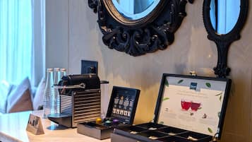 Un espace bar équipé d’une machine à café, d’un infuseur à thé et d’un menu affiché dans un cadre.
