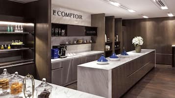 Una cocina moderna con encimera de mármol, electrodomésticos integrados y una zona de café.