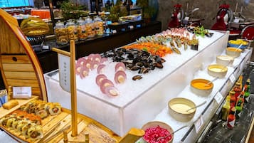 Un bufé con mariscos, sushi y salsas.