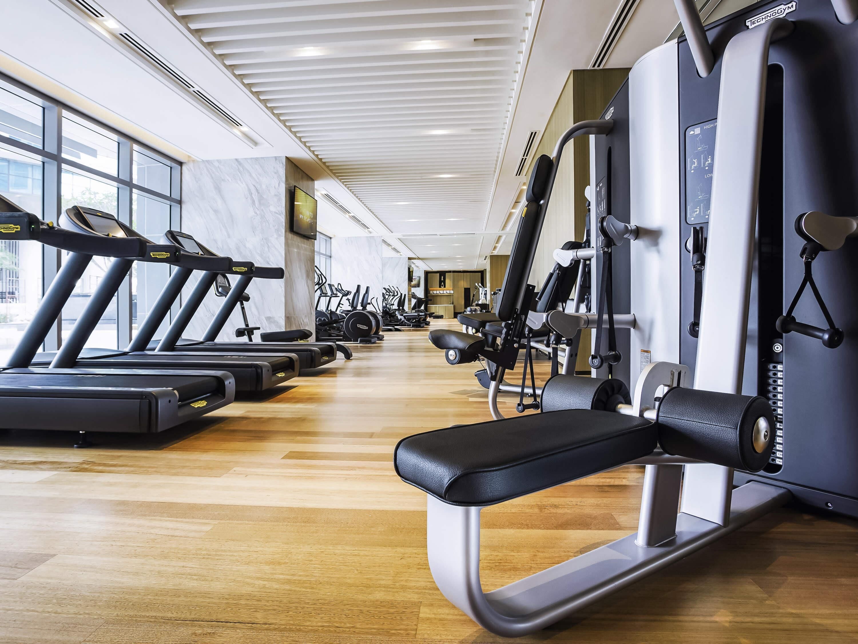 A gym with treadmills, elliptical machines, and weight machines.